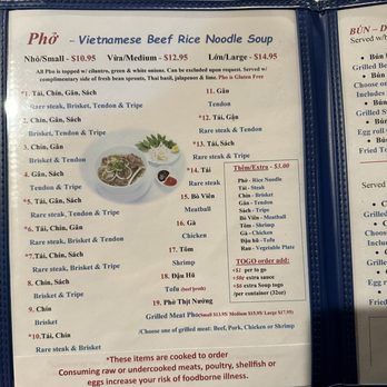Pho Duy - A menu page from a Vietnamese restaurant features a section for Pho, specifically Vietnamese Beef Rice Noodle Soup, with options for small, medium, and large sizes priced at $10.95, $12.95, and $14.95 respectively. The menu lists various beef and seafood options, including rare steak, brisket, tendon, tripe, chicken, shrimp, and tofu, with some items marked as cooked to order. Additional charges for extras such as rice noodles, steak, brisket, tendon, tripe, shrimp, chicken, tofu, and vegetable plates are detailed. The menu emphasizes that all Pho is topped with cilantro, green and white onions, and can be ordered without certain ingredients upon request. - Vietnamese Near Me - Greeley, Colorado