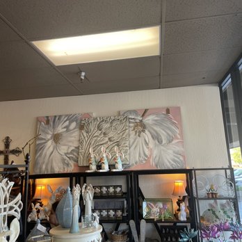 Authentique - Inside.... - Decorative items including bunny figurines, floral paintings, and lamps are arranged on shelves inside a store. - Home Decor Near Me - Fresno, California
