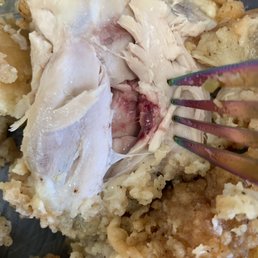 a close up of a piece of chicken being eaten with a fork