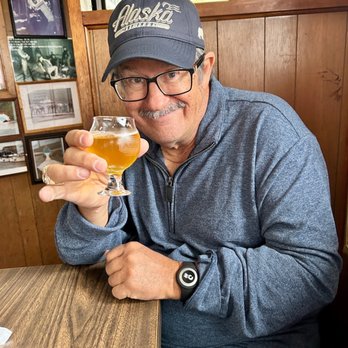 Sourdough Cocktail Bar - a man holding a glass of beer - Cocktail Bars Near Me - Ketchikan, Alaska Sourdough Cocktail Bar - a man holding a glass of beer - Cocktail Bars Near Me - Ketchikan, Alaska