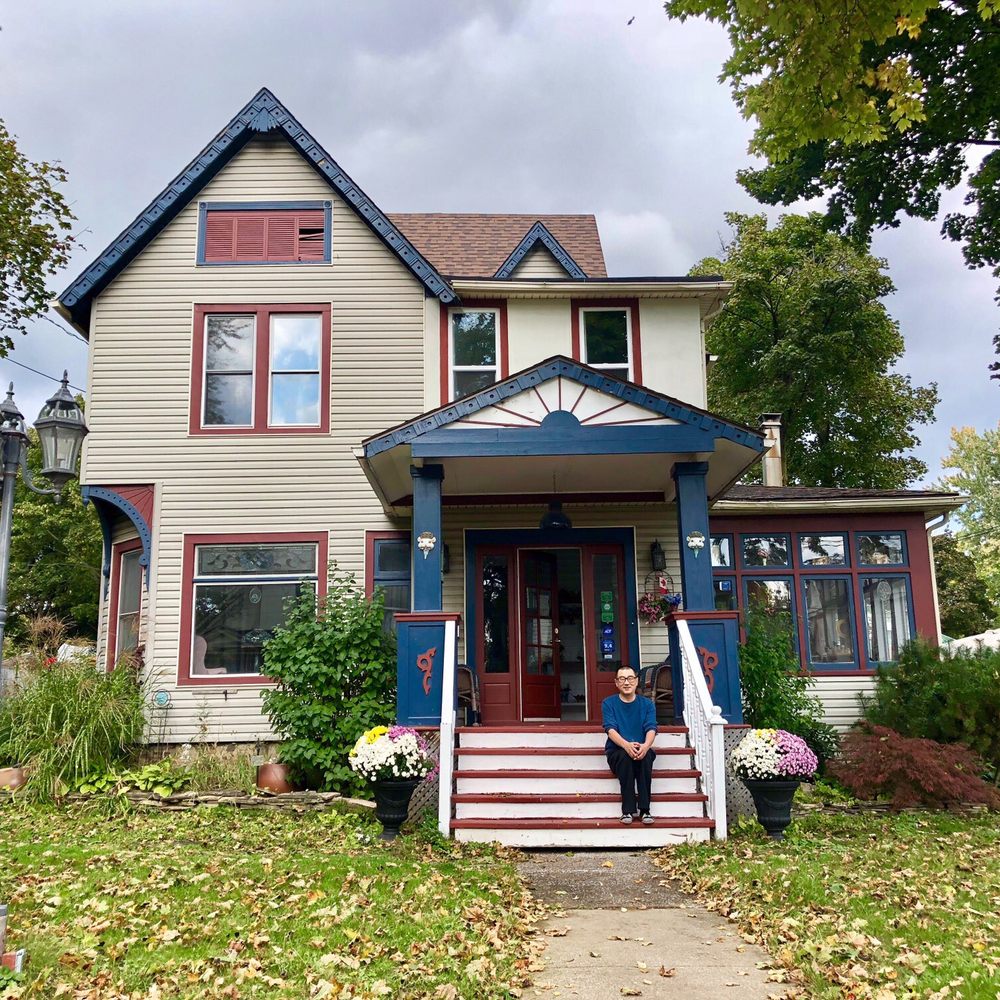 Blue Gables Bed & Breakfast - Blue Gables Inn with Mr. Wei the owner sitting on the stairs - Bed & Breakfast Near Me - Niagara Falls, Ontario