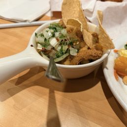 Menudo with chips , onions and chili flakes