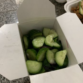 Zandos - The Cuke Salad was refreshing and, oddly, felt perfectly at home amongst a burger and fries. - A white takeout container filled with chopped cucumbers sits on a granite countertop, with water droplets visible on the box. - Food Trucks Near Me - Eugene, Oregon
