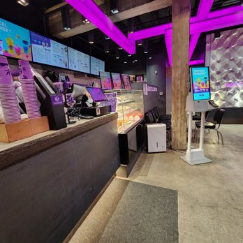 Chatime - A bubble tea shop interior featuring digital menu screens, a counter with cups and equipment, and a seating area with chairs and tables. - Bubble Tea Near Me - Toronto, Ontario