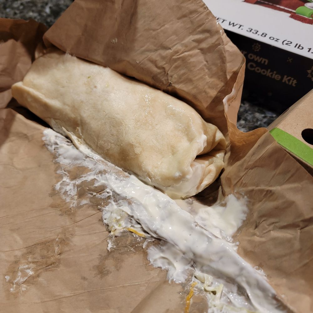 a burrito wrapped in brown paper a burrito wrapped in brown paper