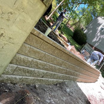 Mow-Town Landscaping - a man working on a retaining wall - Landscaping Near Me Mow-Town Landscaping - a man working on a retaining wall - Landscaping Near Me