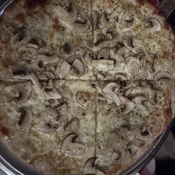 Uncle Tony's - Mushroom pizza - notice the perfect thin crust!! - A pizza topped with sliced mushrooms and melted cheese, featuring a thin crust. The pizza is served on a round metal tray, with a slightly charred edge visible. The background includes a checkered tablecloth, indicating a dining setting. - Italian Near Me - Toronto, Ontario