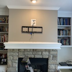 Mounting Madness - Adding a new outlet above the fireplace, code compliant, and there are feeds for HDMI cords to the shelving below! Sweet!