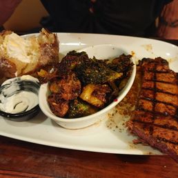 NY Strip with baked potato and blackened Brussel Sprouts