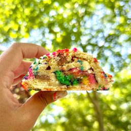 a hand holding a piece of cake