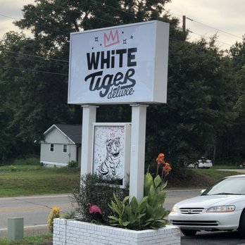 White Tiger Deluxe - a white car parked in front of the sign - New American Near Me - Watkinsville, Georgia White Tiger Deluxe - a white car parked in front of the sign - New American Near Me - Watkinsville, Georgia