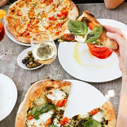 Napolese Pizzeria - Table spread of summer favs: Summer Love Pie, Green Margherita, and Caprese.