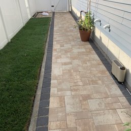 a brick walkway in a backyard a brick walkway in a backyard