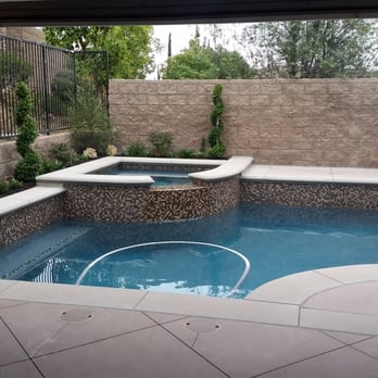 Bayrich Construction - Pool with concrete coping and decks.  Mosaic tile on the raised bond beam, with mini pebble tec plaster. - General Contractors Near Me - Anaheim, California