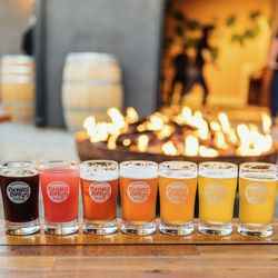 Benny Boy Brewing - Flight of beer in front of  a firepit