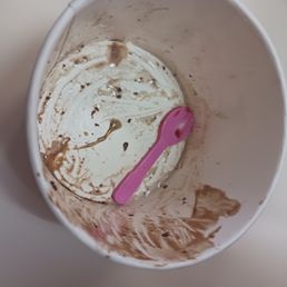 a dirty cup with a pink spoon in it