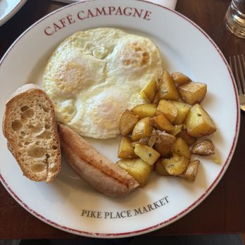 Café Campagne - Three over medium eggs served with chicken and pork sausage with fried rosemary potatoes and baguette - French Near Me - Seattle, Washington Café Campagne - Three over medium eggs served with chicken and pork sausage with fried rosemary potatoes and baguette - French Near Me - Seattle, Washington