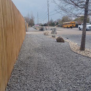 Acorn Landscaping - a gravel driveway and a wooden fence - Landscaping Near Me