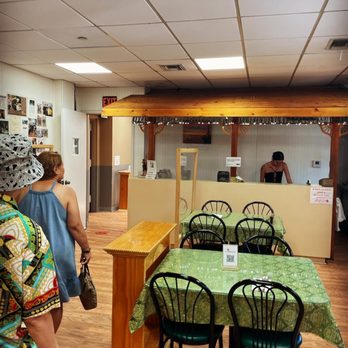 Ihawan - a woman standing in front of a counter in a restaurant - Filipino Near Me - Woodside, New York Ihawan - a woman standing in front of a counter in a restaurant - Filipino Near Me - Woodside, New York