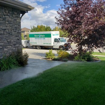 Next Rain Irrigation - a moving truck parked in front of a house - Landscaping Near Me - Calgary, Alberta