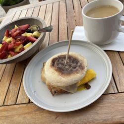 Fresh fruit, egg and cheese English muffin, with fresh coffee.