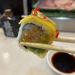 Mizu Sushi - C.I.A Roll $15 Spicy yellowtail, avocado, mango & crunch, inside, mango on top with chef' special sauce, Tobiko & golden powder
