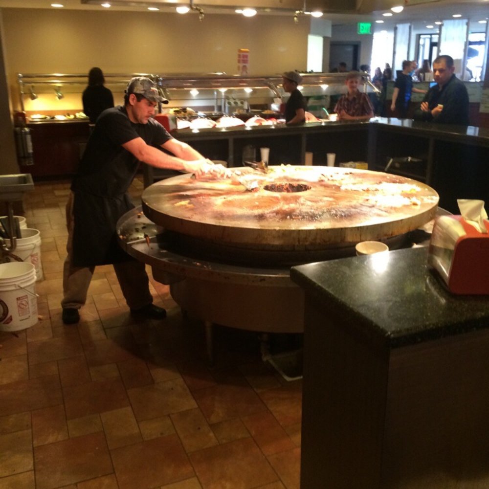 China Buffet & Mongolian Grill - a woman preparing a pizza - Buffets Near Me - Lincoln, Nebraska