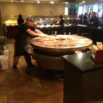 China Buffet & Mongolian Grill - a woman preparing a pizza - Buffets Near Me - Lincoln, Nebraska