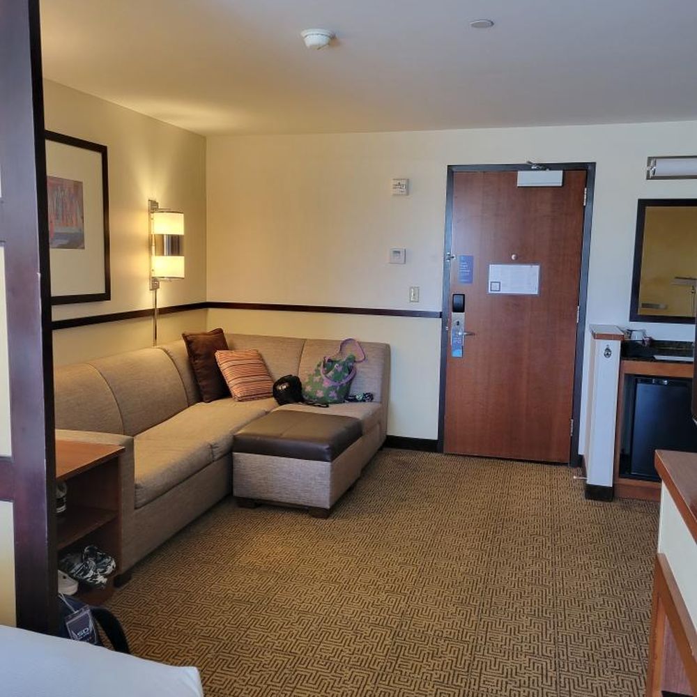 Hyatt Place Phoenix/Mesa - comfy sofa area with mini fridge, coffee machine, table with lamp to the side - Hotels Near Me - Mesa, Arizona Hyatt Place Phoenix/Mesa - comfy sofa area with mini fridge, coffee machine, table with lamp to the side - Hotels Near Me - Mesa, Arizona