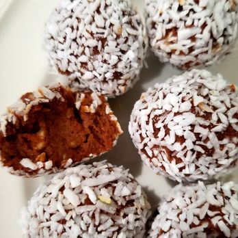Raw-licious - a plate of chocolate and coconut balls - Specialty Food Near Me