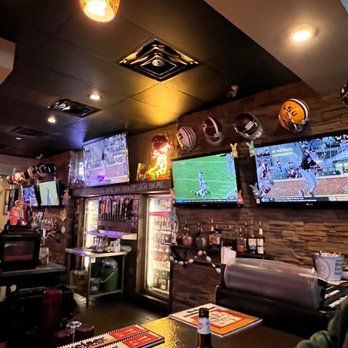 Boars Nest - a man sitting at a bar watching a football game - Sports Bars Near Me - Rogers, Arkansas
