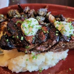 Crave American Kitchen & Sushi Bar - New York strip w/herb & truffle butter, crispy brussels, & buttermilk mashed potatoes.