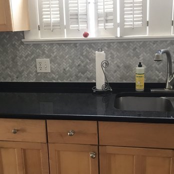 Versatile Builders - a kitchen with black counter tops - Tiling Near Me - Quincy, Massachusetts