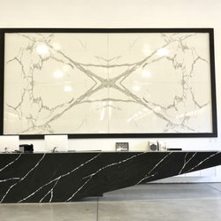 Bookmatched porcelain slabs on the wall and a gigantic quartz reception desk to start off your tour!