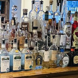 bottles of alcohol lined up on a bar bottles of alcohol lined up on a bar