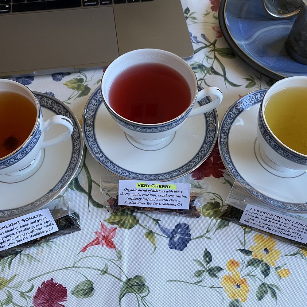 Sample packets of Moonlight Sonata, Very Cherry, and Luscious Meyer Lemon resting against cups and saucers. Sample packets of Moonlight Sonata, Very Cherry, and Luscious Meyer Lemon resting against cups and saucers.