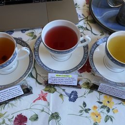 Sample packets of Moonlight Sonata, Very Cherry, and Luscious Meyer Lemon resting against cups and saucers. Sample packets of Moonlight Sonata, Very Cherry, and Luscious Meyer Lemon resting against cups and saucers.