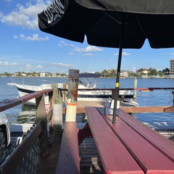 Wahoo's Bayside Pub and Grill - The rear outside dining area with a visitor by boat at the dock - Seafood Near Me - Redingtn Shor, Florida Wahoo's Bayside Pub and Grill - The rear outside dining area with a visitor by boat at the dock - Seafood Near Me - Redingtn Shor, Florida