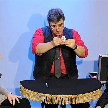 Smoke & Mirrors Magic Theater - Magician Mark Zacharia tears and then restores a signed playing card. - Performing Arts Near Me - Glenside, Pennsylvania