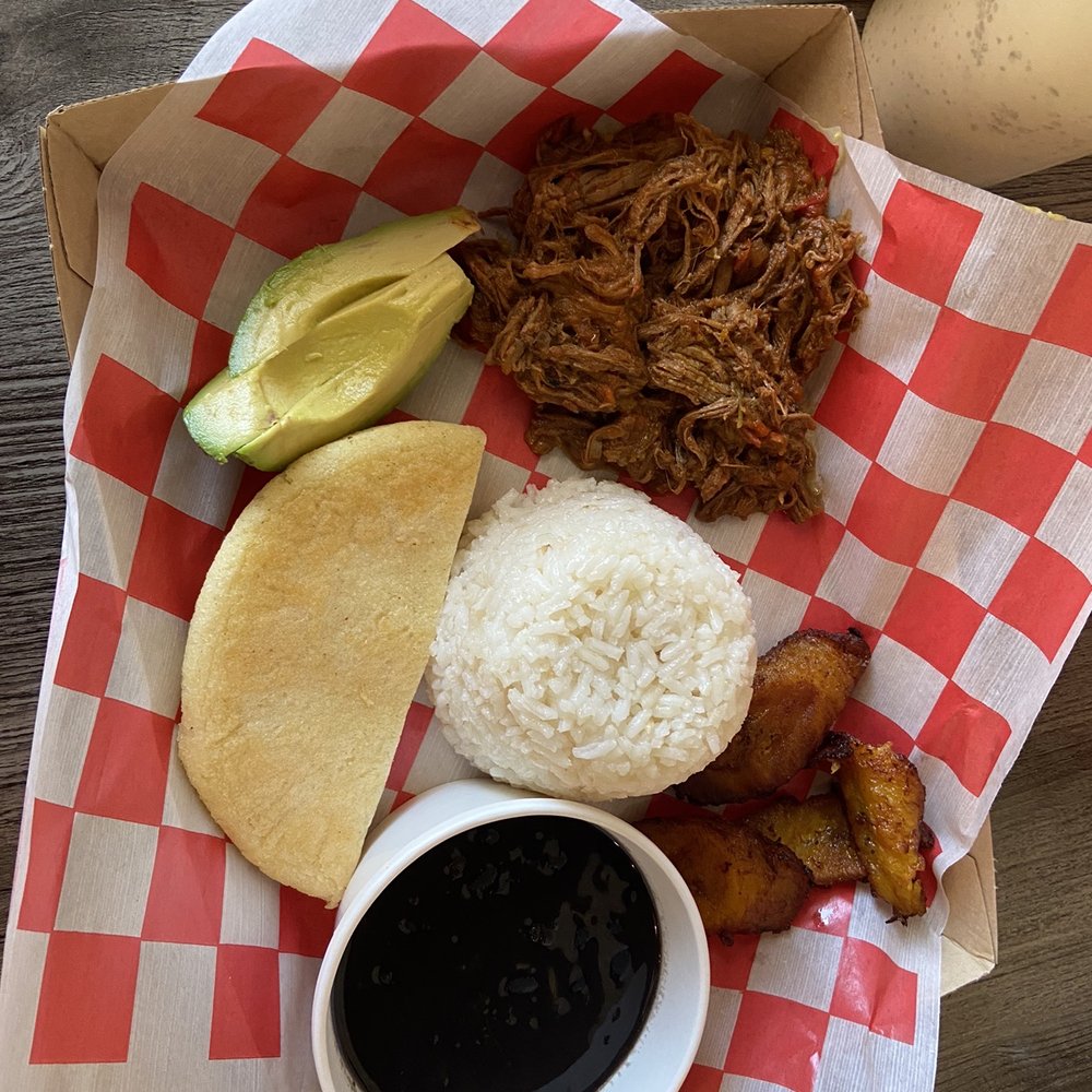 Cafe Unique - a plate of pulled pork, rice, potatoes, and a pickle - Venezuelan Near Me - Midland, Texas