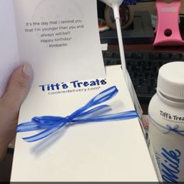 a person holding a box of tiff's treats