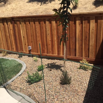 Lee's Landscape - a fenced in area with a tree - Landscaping Near Me