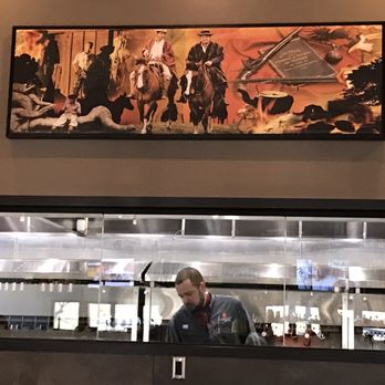 Churrasco de Brasil - Great view of the grills through the glass below the painting. - Brazilian Near Me - Tucson, Arizona