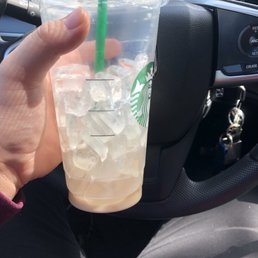a hand holding a starbucks drink