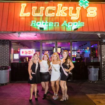 Lucky's Rotten Apple - a group of women standing in front of a neon sign - Sports Bars Near Me - Destin, Florida Lucky's Rotten Apple - a group of women standing in front of a neon sign - Sports Bars Near Me - Destin, Florida