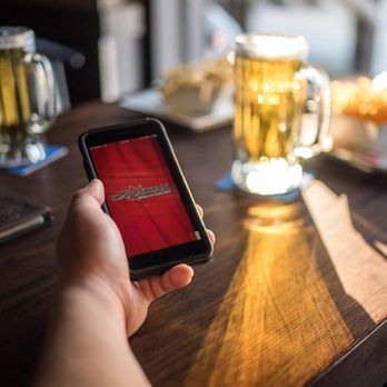 The Canadian Brewhouse - a person holding a smart phone - Canadian (New) Near Me - Saskatoon, Saskatchewan