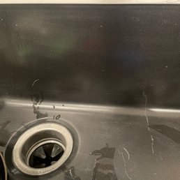 Black scratched sink.  Guess it has to stay that way because they wont tell me how to repair it.  Plus sink leaks when the sprayer is in use