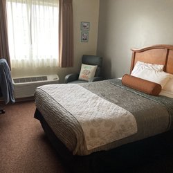 Country Hearth Inn & Suites Edwardsville St. Louis - Bed near window in a two-queen-beds room.
