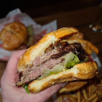 The Mighty - a hand holding a sandwich and french fries - Burgers Near Me - Arvada, Colorado The Mighty - a hand holding a sandwich and french fries - Burgers Near Me - Arvada, Colorado