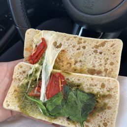 a person holding a sandwich in their hand